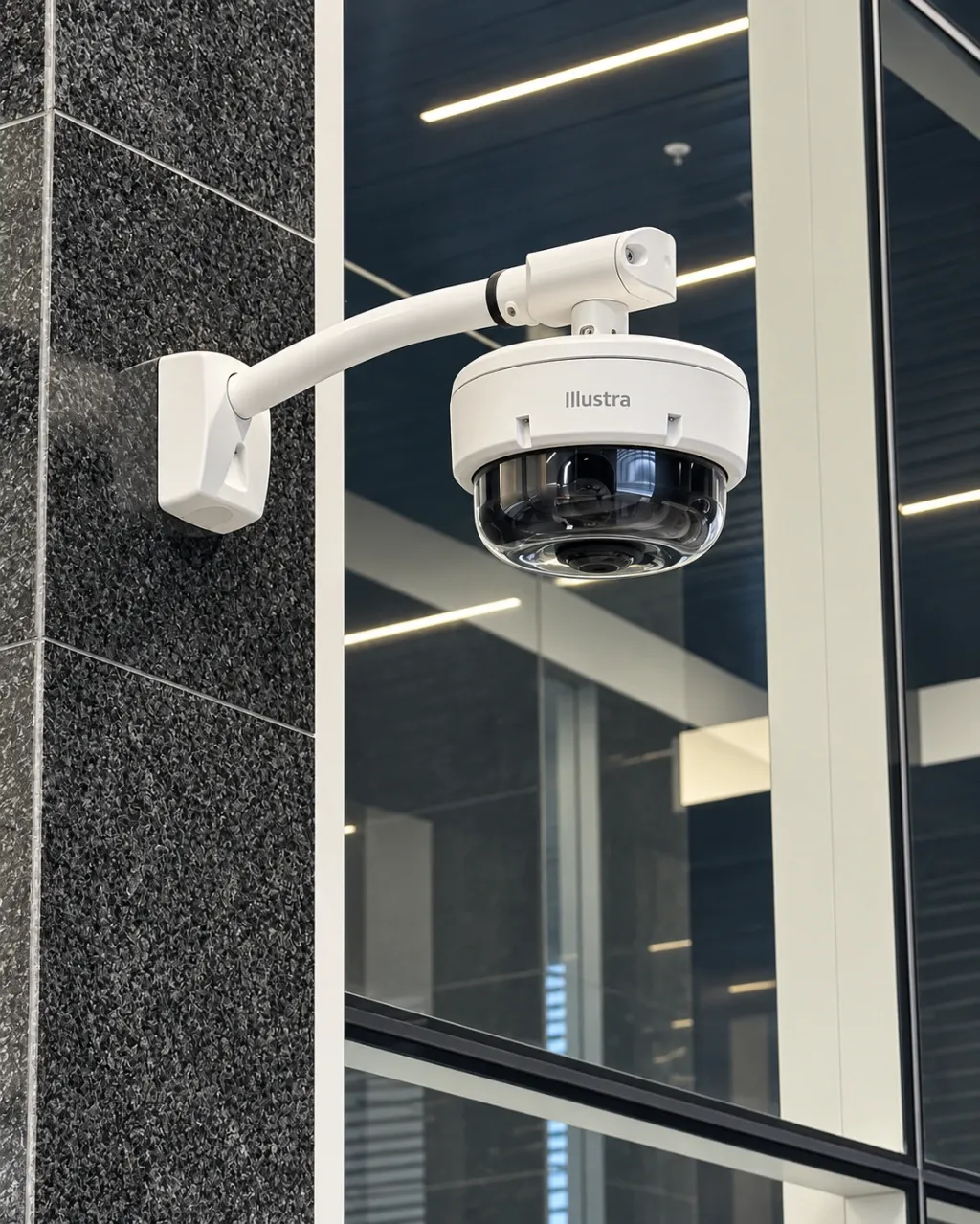 Cámara de videovigilancia Illustra instalada en la fachada de un edificio corporativo